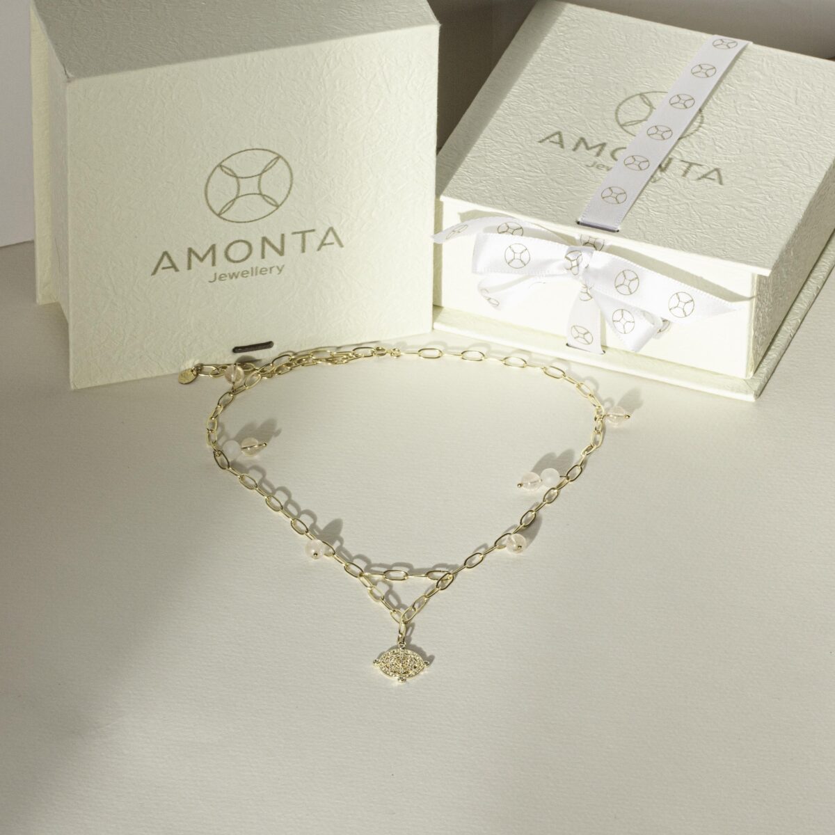 Morganite Rose Quartz necklace with chunky gold-filled chain displayed in front of AMONTA jewellery gift boxes, styled in soft natural light