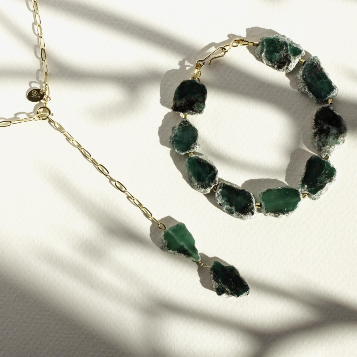 Green Fuchsite gemstone bracelet and necklace set with raw, unpolished stones and gold-filled chain, displayed on a sunlit white background