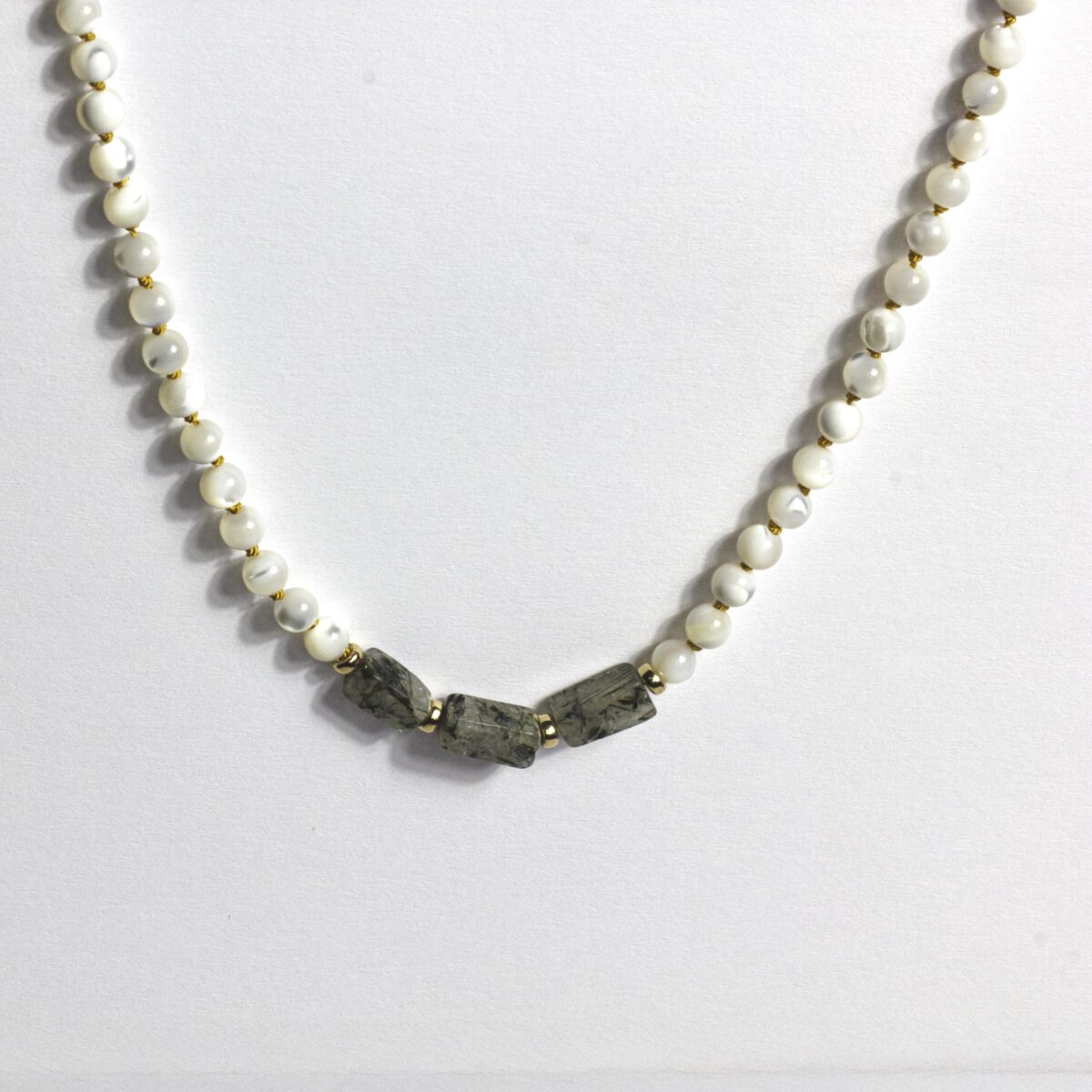 Close-up of Mother of Pearl and Tourmaline Quartz necklace with gold-filled spacers, strung on yellow silk thread – handcrafted gemstone jewellery for calm and clarity.