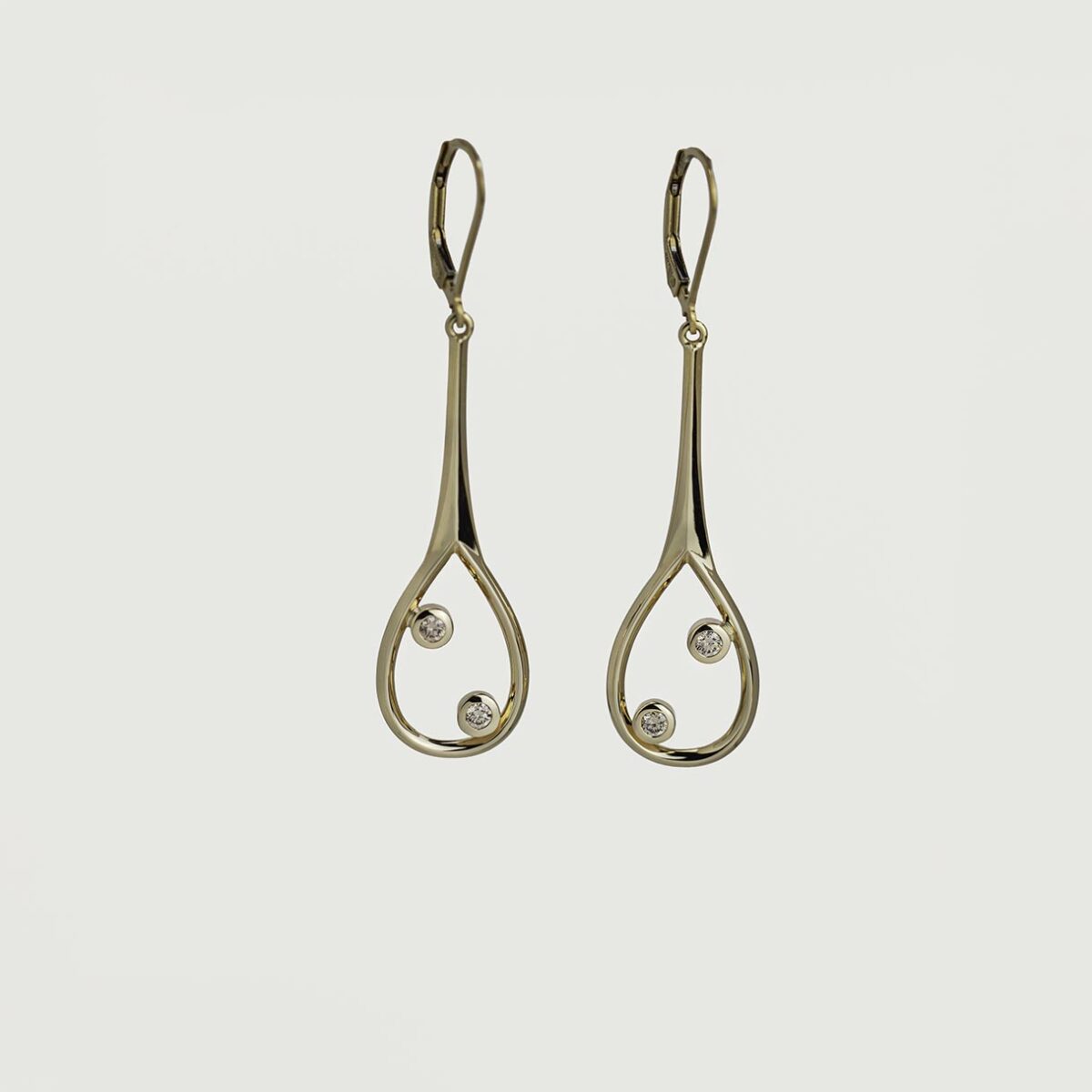 Elegant drop earrings in 9k gold featuring two bezel-set champagne diamonds in a delicate open teardrop design, displayed on a soft light grey background.