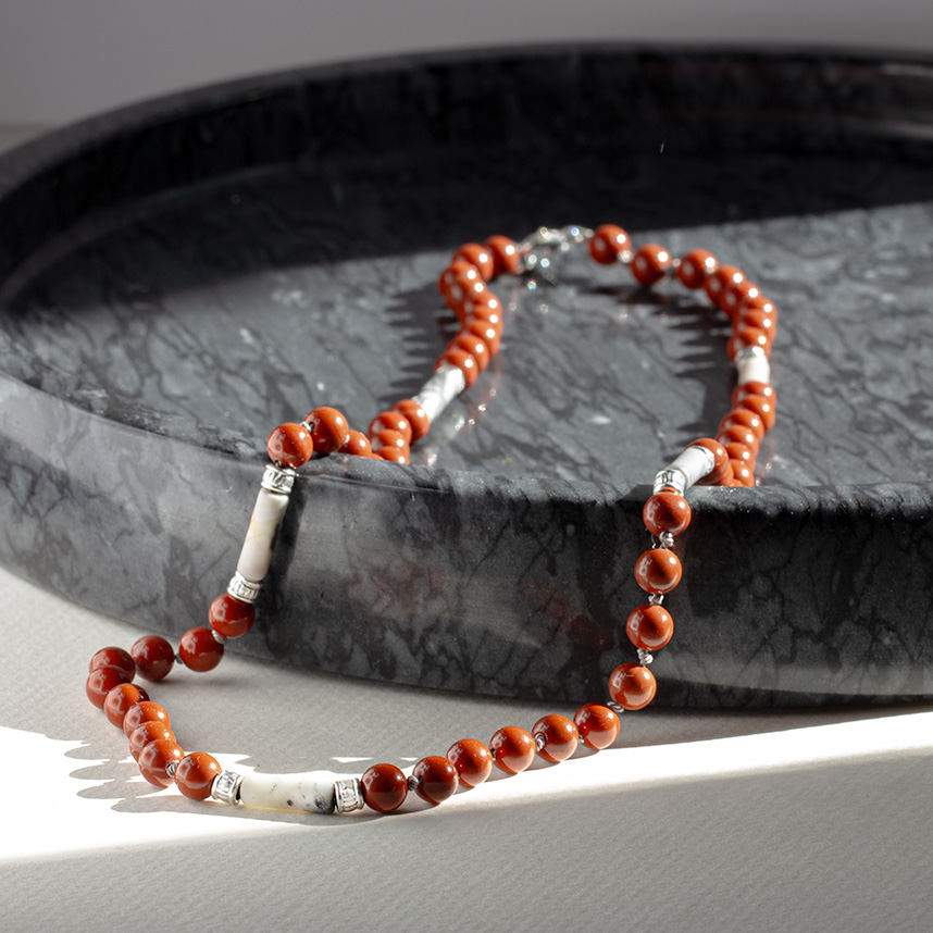 Handmade Iron Earth Men’s Necklace displayed on dark marble surface with red jasper beads