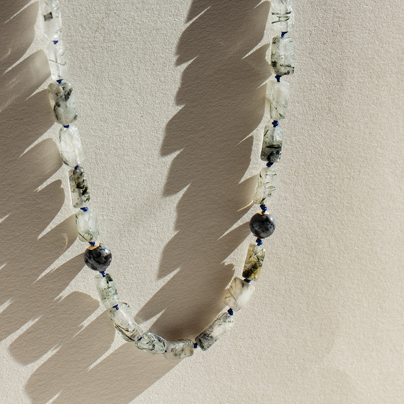 Close-up of men’s tourmaline obsidian choker necklace showing natural gemstone details, blue silk thread, and gold-filled spacers.