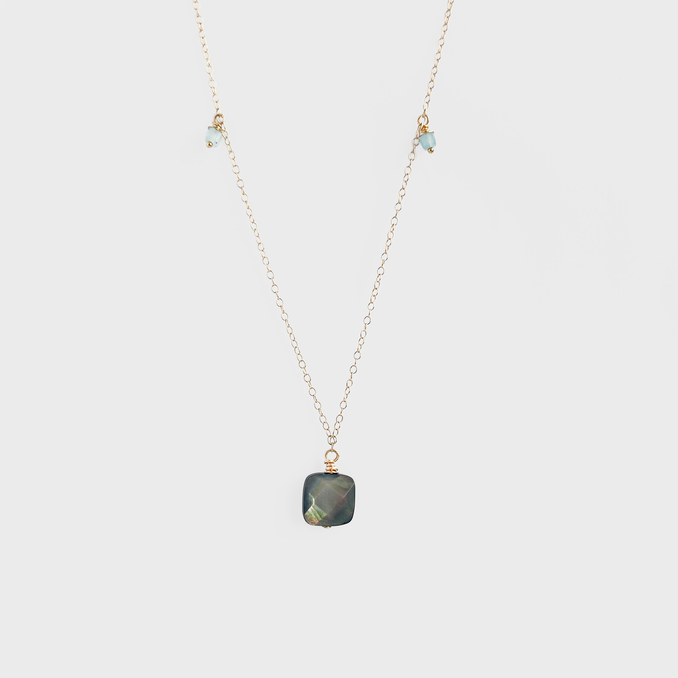 Inner Calm Aquamarine Pearl Necklace featuring a gold-filled chain with a soft grey mother of pearl pendant and two aquamarine beads, symbolising serenity and balance.
