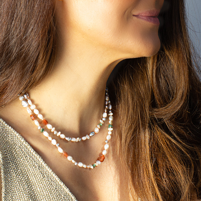 Soft Radiance Pearl Emerald Necklace layered around the neck, featuring mixed pearls, emeralds, and moonstone beads on pink silk with a 9K gold clasp, radiating soft elegance and serenity