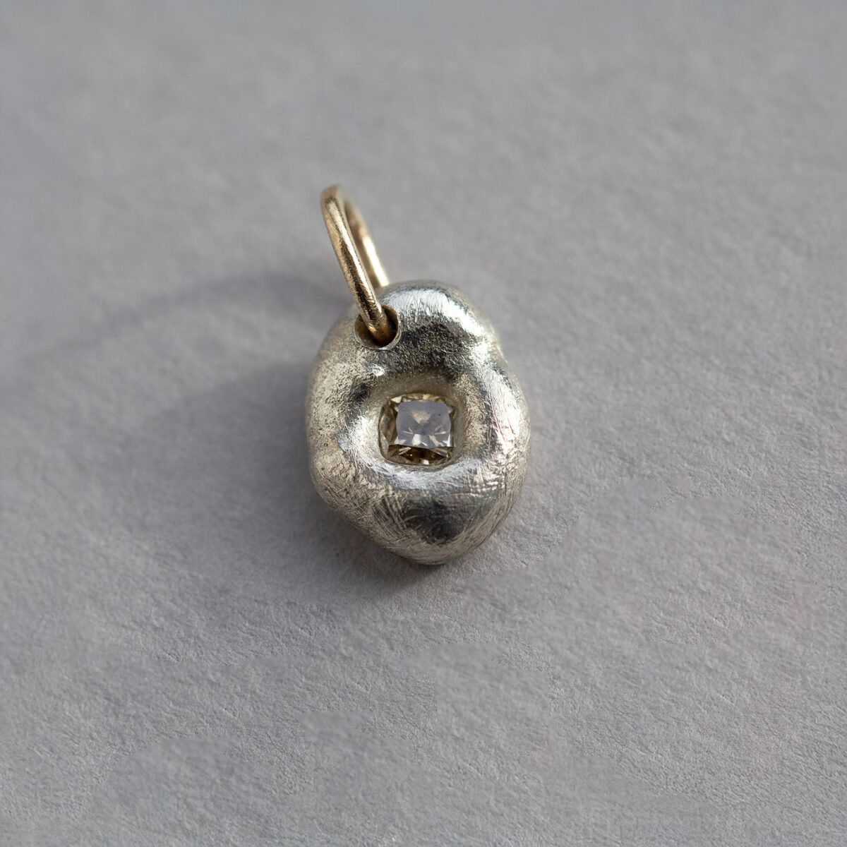 Organic-shaped Argentium silver pendant with a square champagne diamond set in a recessed centre.